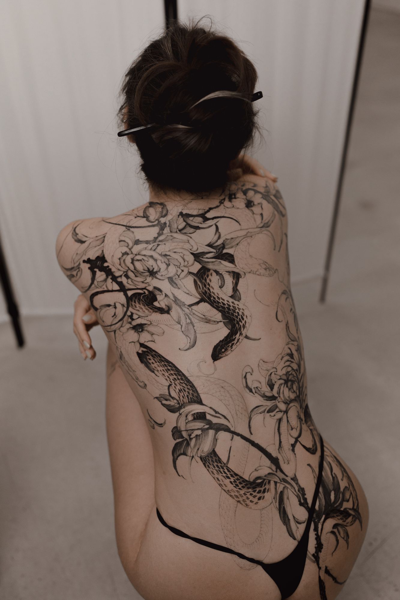 Large-scale snake and chrysanthemum tattoo covering the back